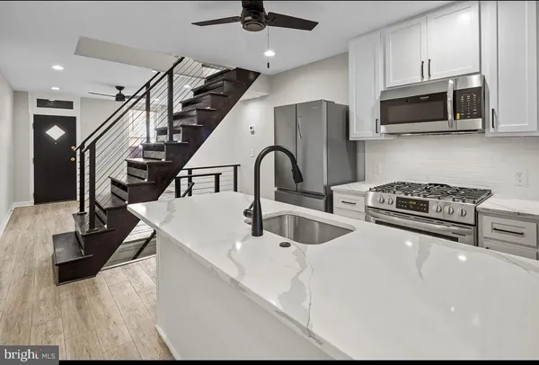 a kitchen with stainless steel appliances kitchen island granite countertop a sink a stove and cabinets