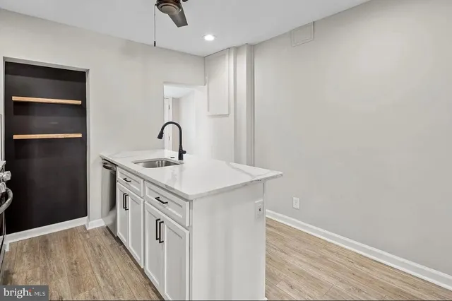 a kitchen with a sink cabinets and wooden floor
