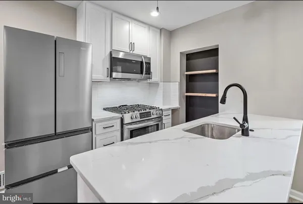 a kitchen with stainless steel appliances a refrigerator stove and microwave