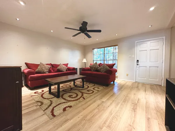 a living room with furniture and a wooden floor