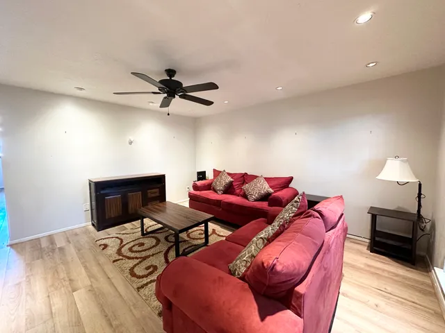 a living room with furniture a ceiling fan and a rug