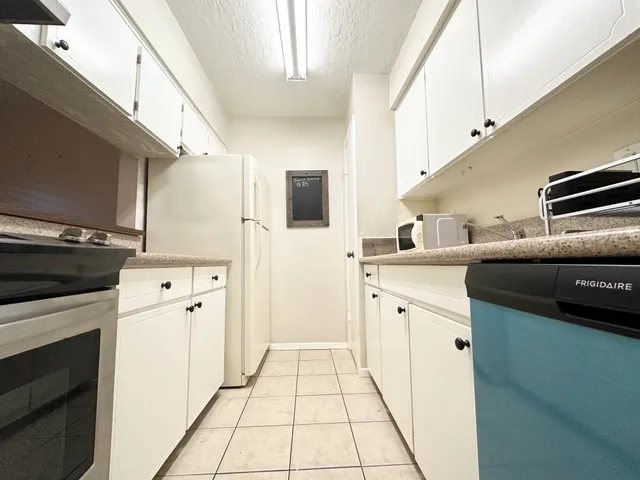 a kitchen with stainless steel appliances kitchen island granite countertop a refrigerator and a stove top oven