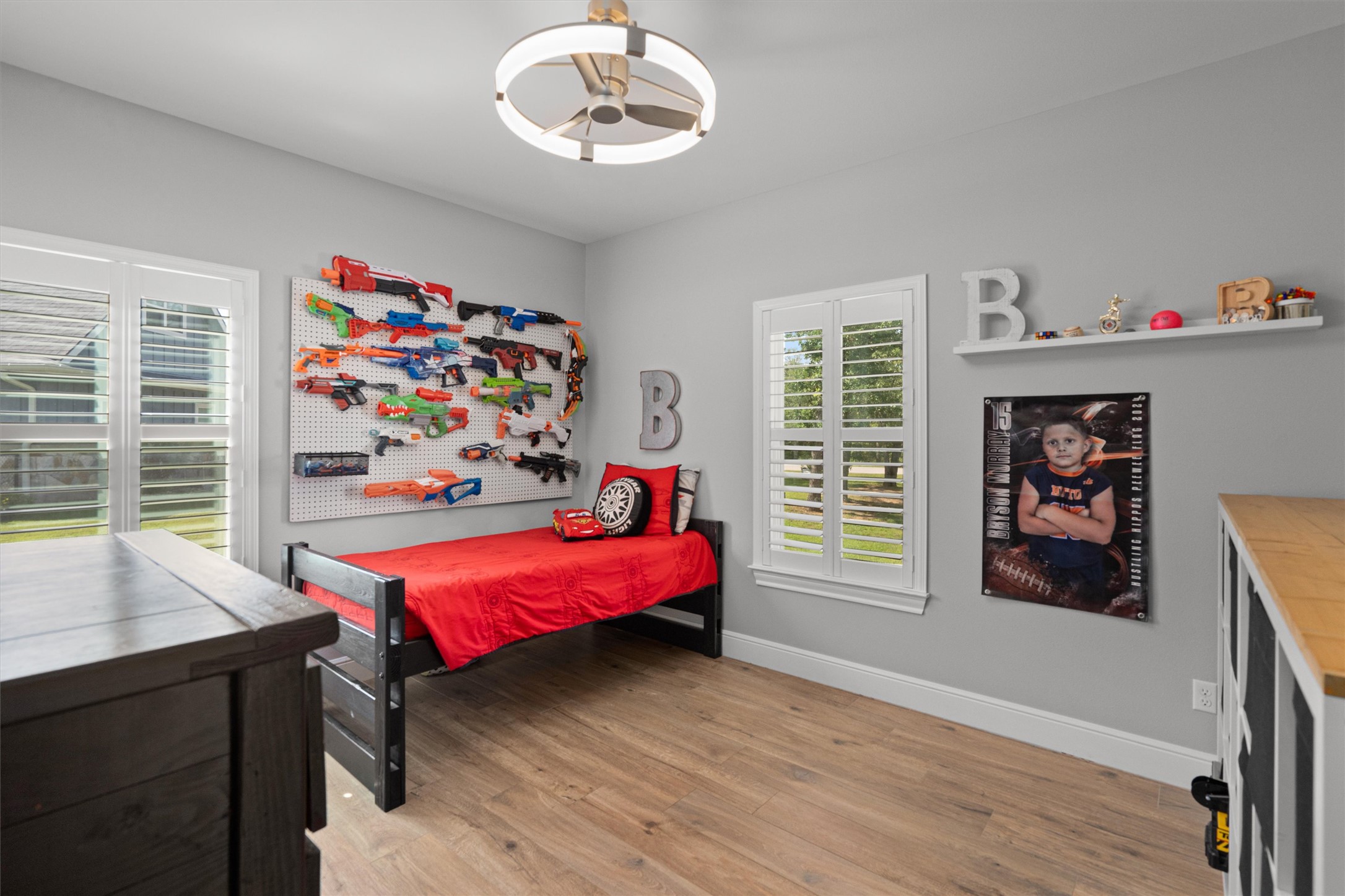 136 Fawn Hollow Elgin, TX 78621 - Photo 23 of 40 Bedroom 2 featuring wood-finish flooring, light gray wall paint, and two windows with white plantation shutters