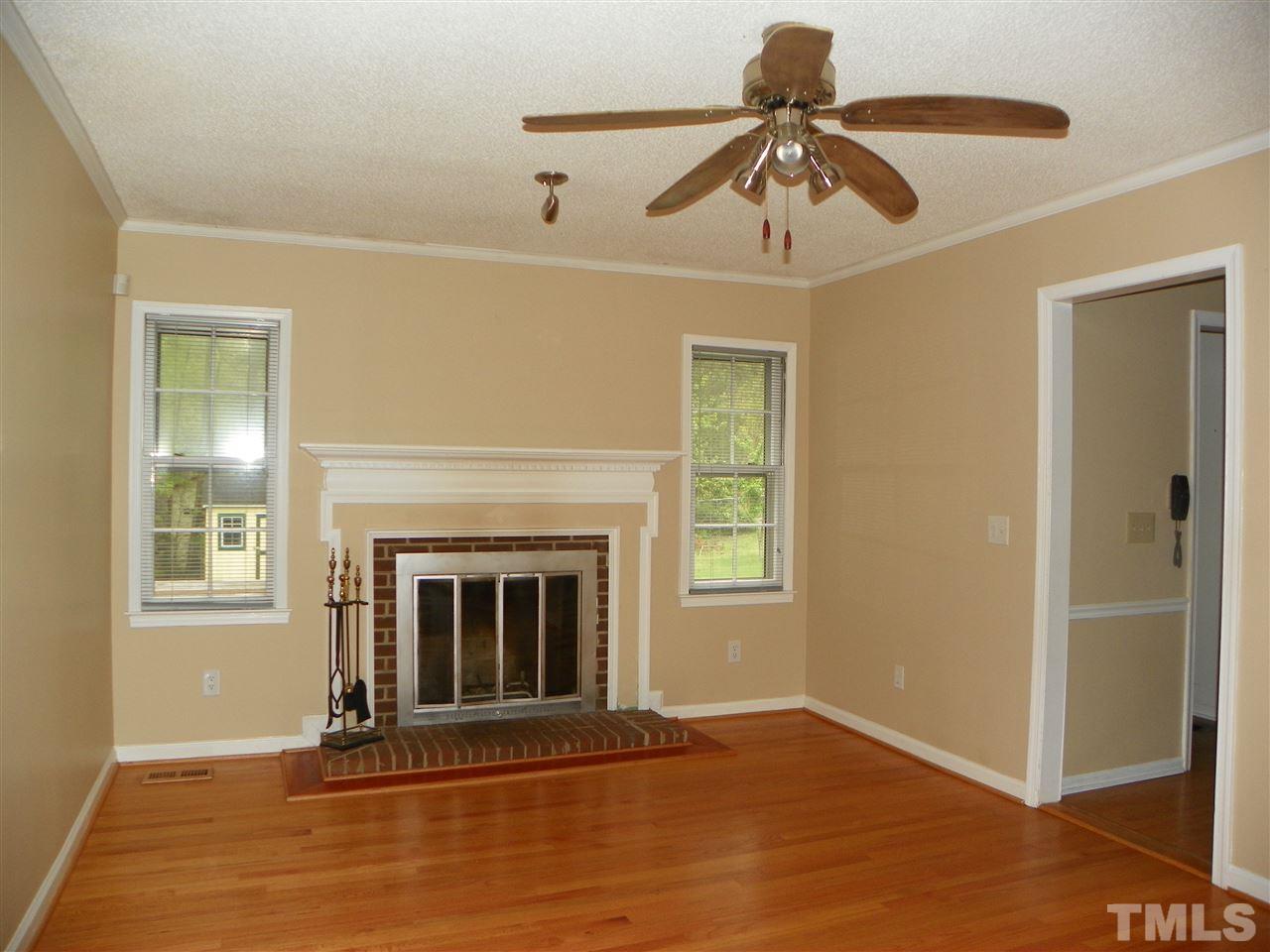 5115 McCormick Road Durham, NC 27713 - Photo 5 of 11 a living room with a fireplace and wooden floor