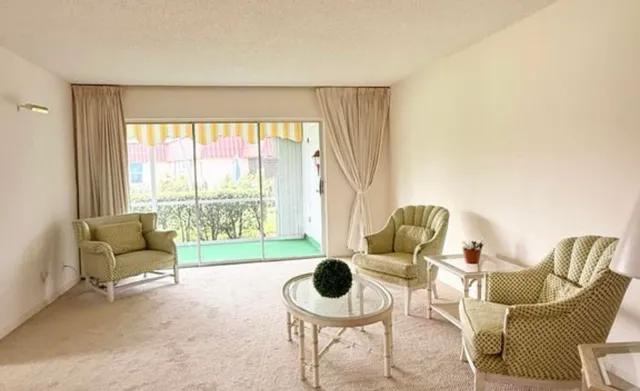 a living room with furniture and a floor to ceiling window