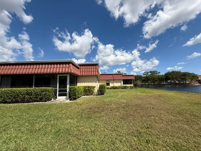 a view of a house with a big yard and a large tree