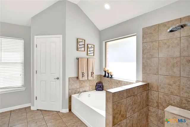 a bathroom with a tub a sink and a large mirror