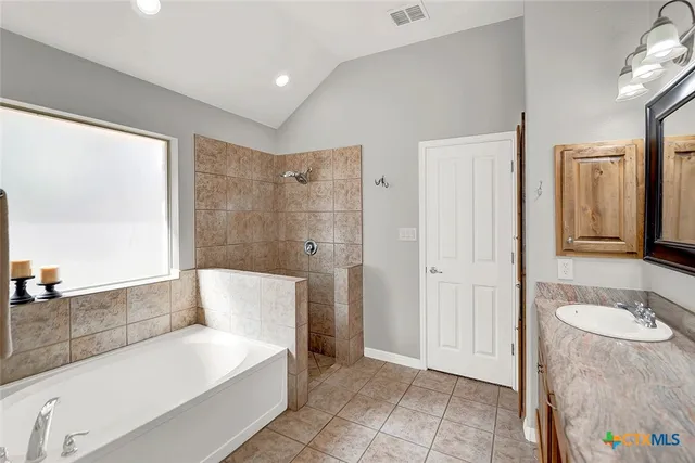 a bathroom with a tub sink and mirror