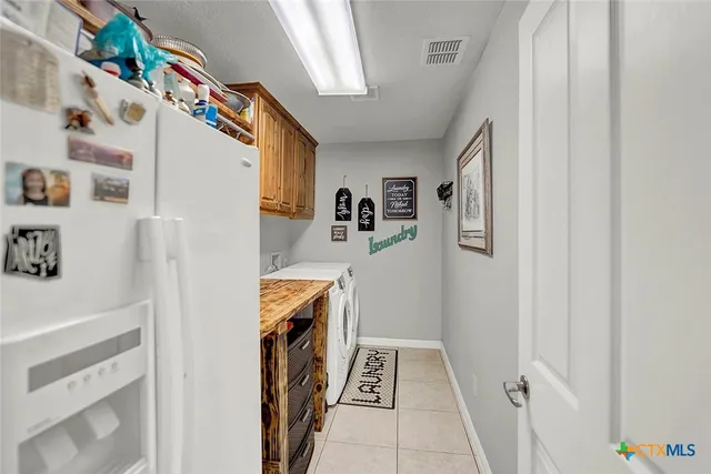 a storage room with fridge and wooden floor