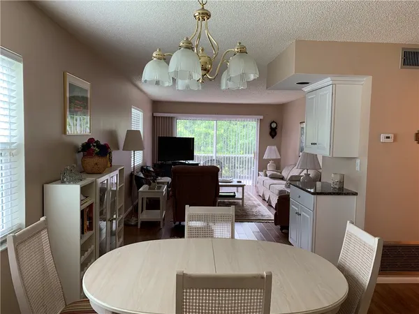 a view of a dining room with furniture a chandelier and wooden floor