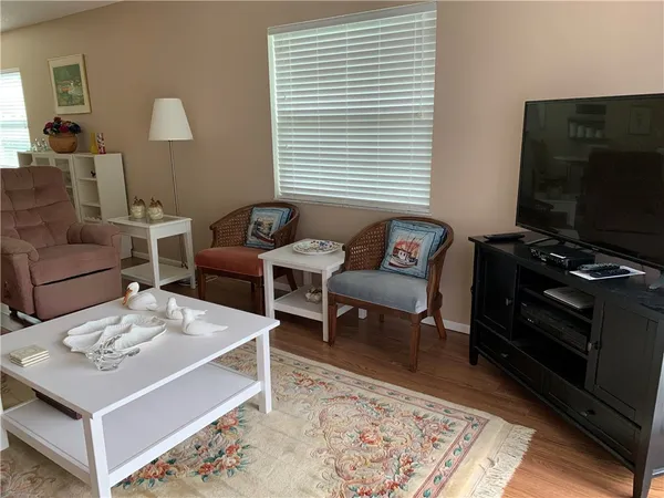 a living room with furniture a flat screen tv and a window