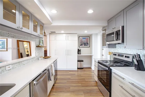 a kitchen with stainless steel appliances a stove microwave and a refrigerator