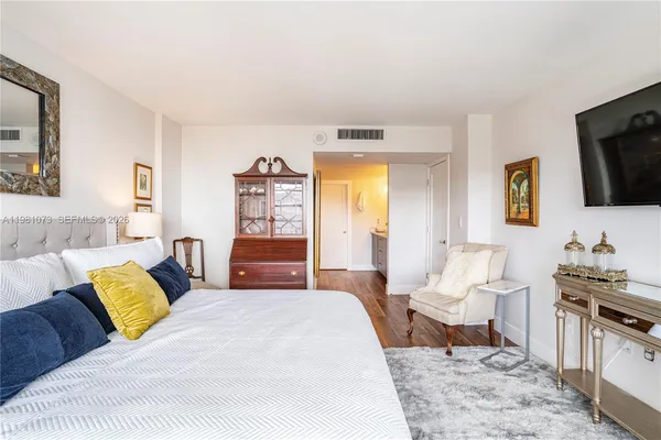 a spacious bedroom with a bed and a flat screen tv