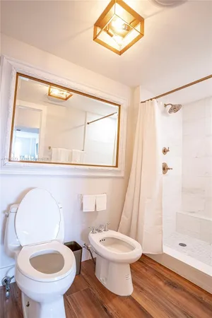 a white toilet sitting next to a bathroom sink and a shower