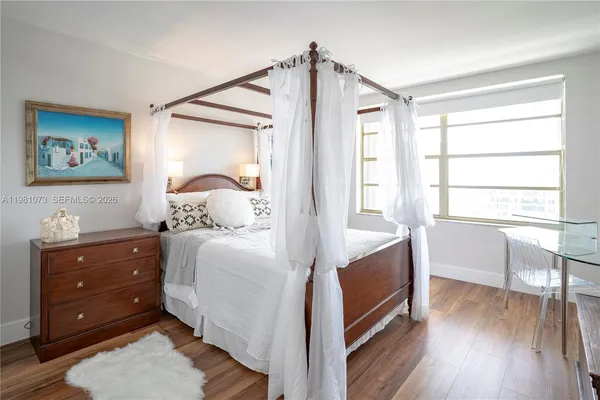 a bedroom with a bed and a tv on the dresser