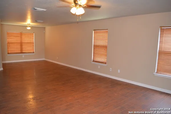 an empty room with windows and fan