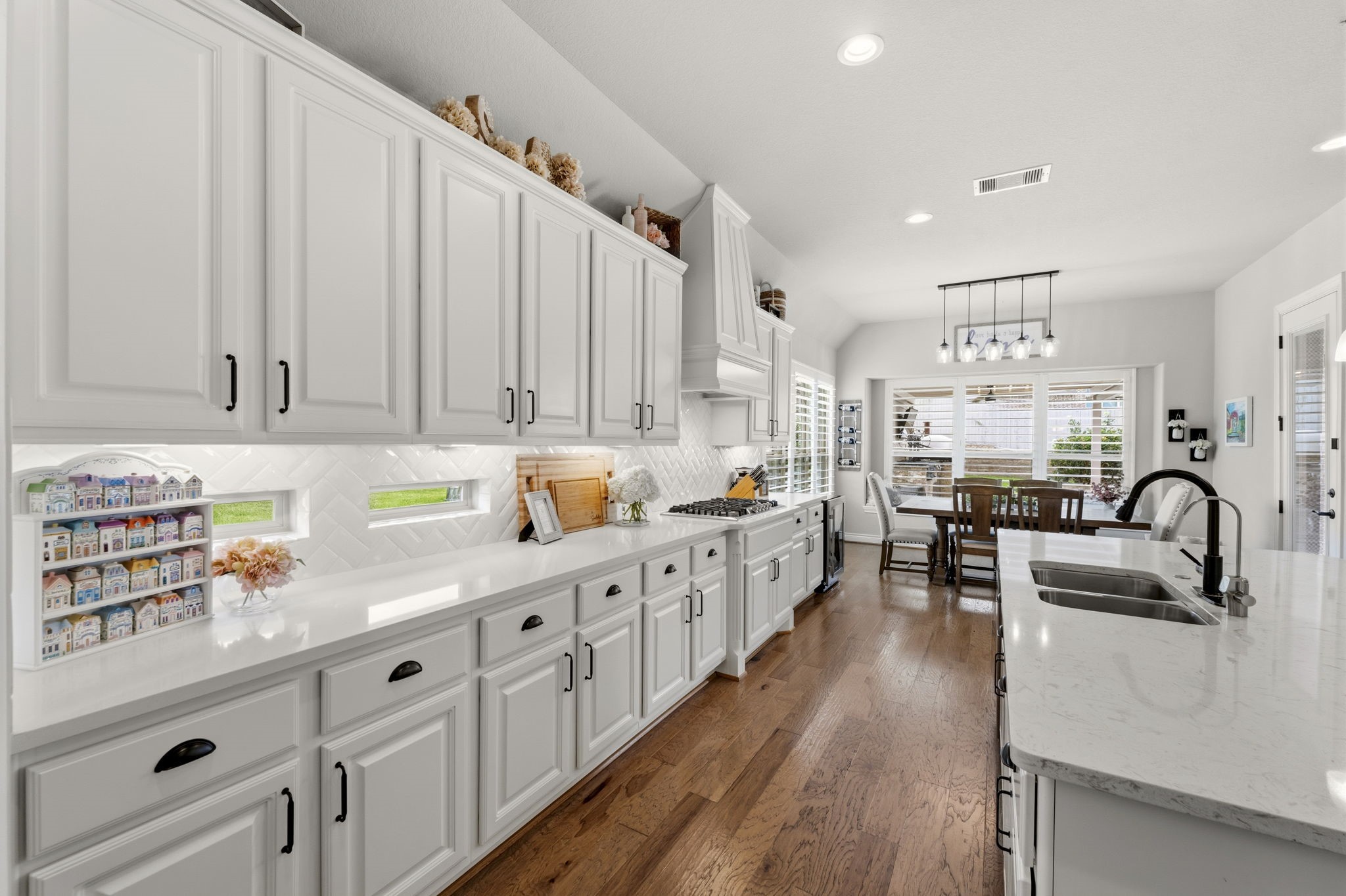 14012 Beartooth Bend Trail Conroe, TX 77384 - Photo 49 of 50 The thoughtfully designed open-concept floor plan allows the kitchen to seamlessly flow into the dining room and family room, creating the perfect space for both everyday living and entertaining. Two horizontal ribbon windows above the counters create a bright, contemporary feel.
