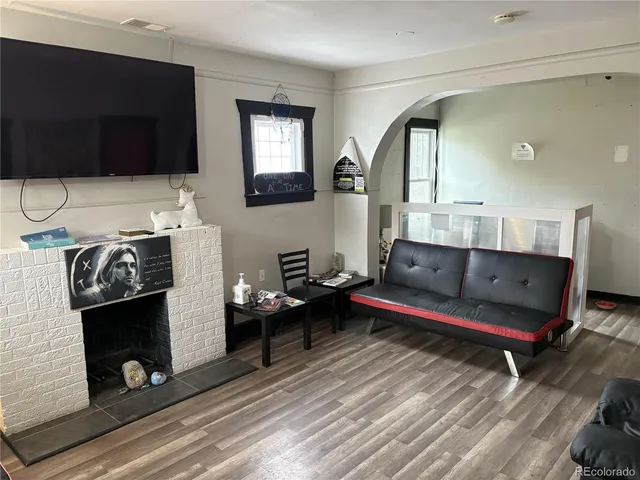 a living room with furniture a flat screen tv and a fireplace