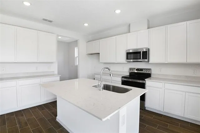 a kitchen with a sink a stove and cabinets