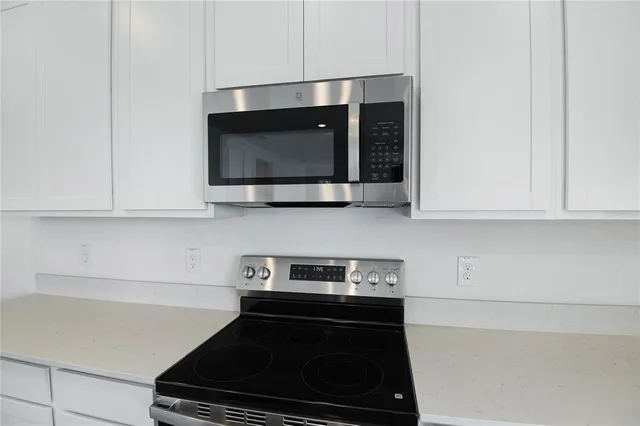 a kitchen with stainless steel appliances a stove and a microwave