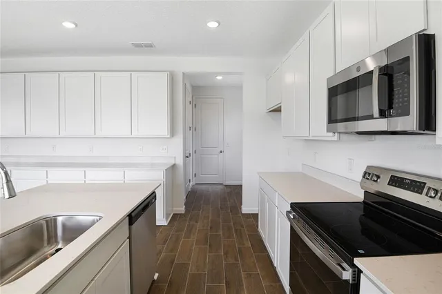 a kitchen with a sink stove and microwave