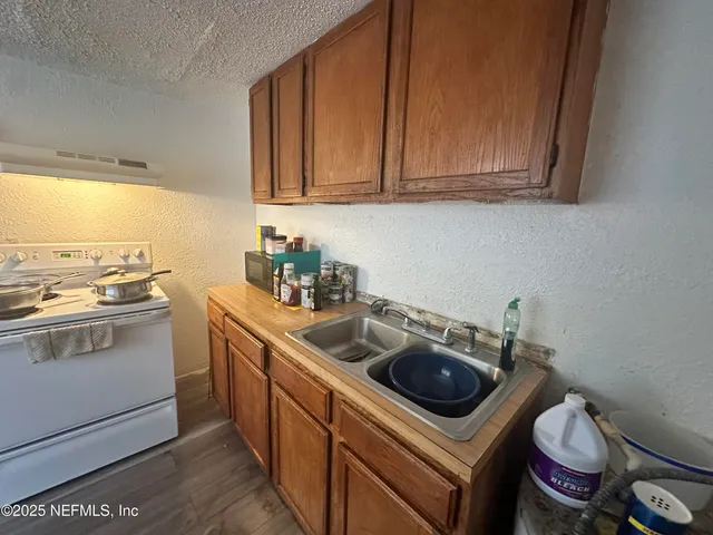 a kitchen with a sink a stove and cabinets