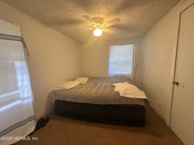 a bed sitting in a bedroom next to a window