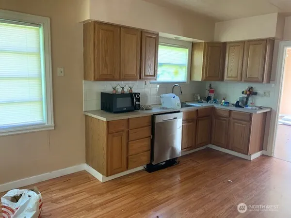 a kitchen with a sink cabinets and wooden floor