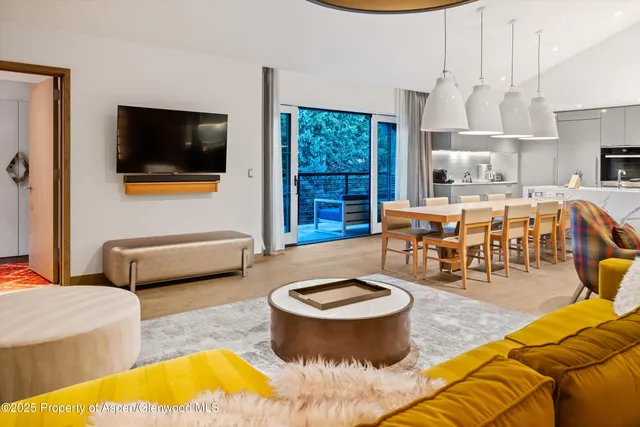 a living room with furniture a flat screen tv and a large window