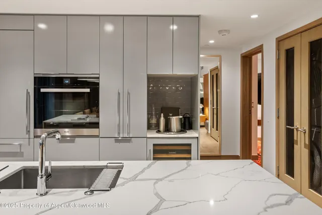 a kitchen with stainless steel appliances kitchen island granite countertop a refrigerator and a sink