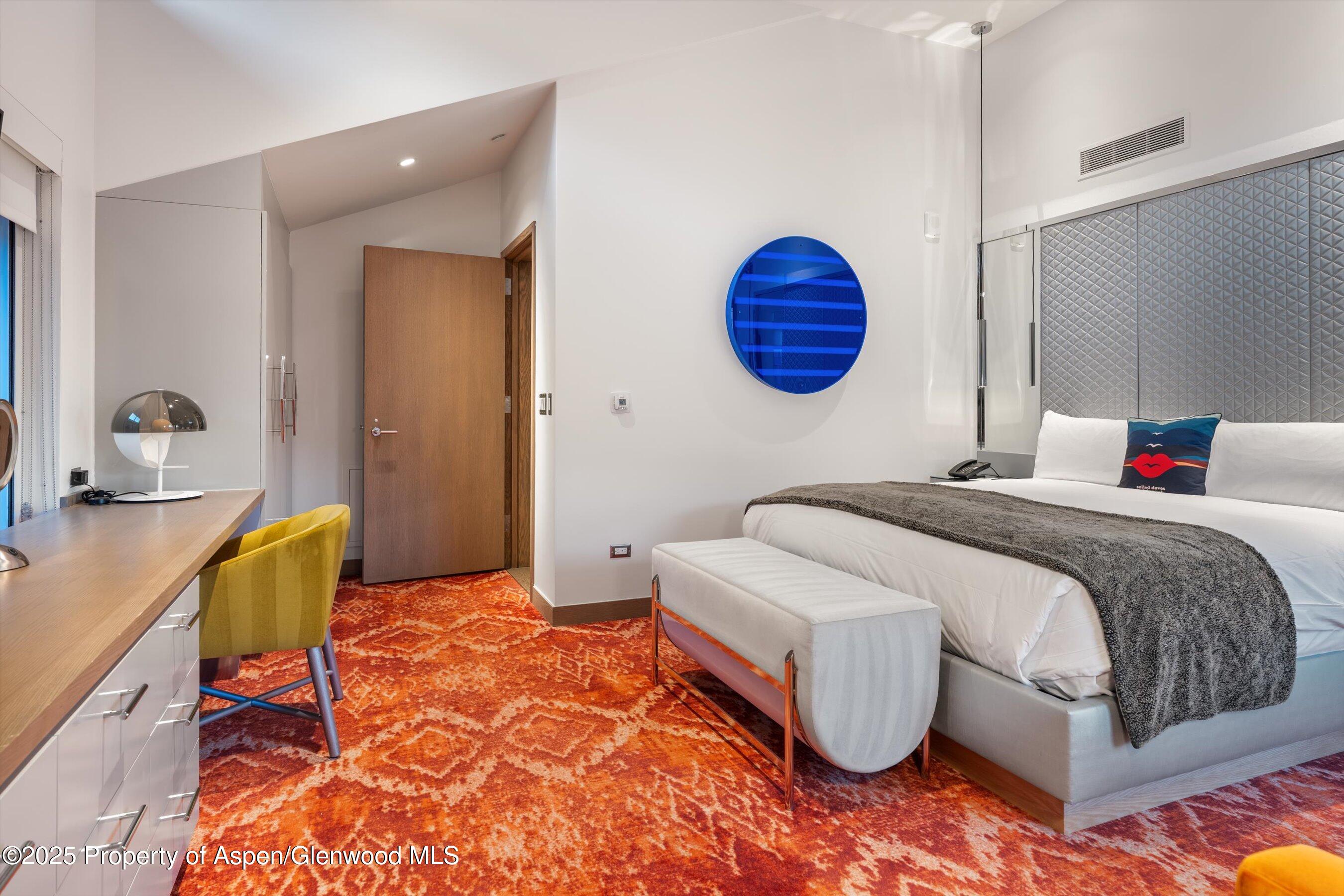 550 South Spring Street, Unit F10 110 Aspen, CO 81611 - Photo 25 of 58 a bedroom with a bed and a lamp on dresser