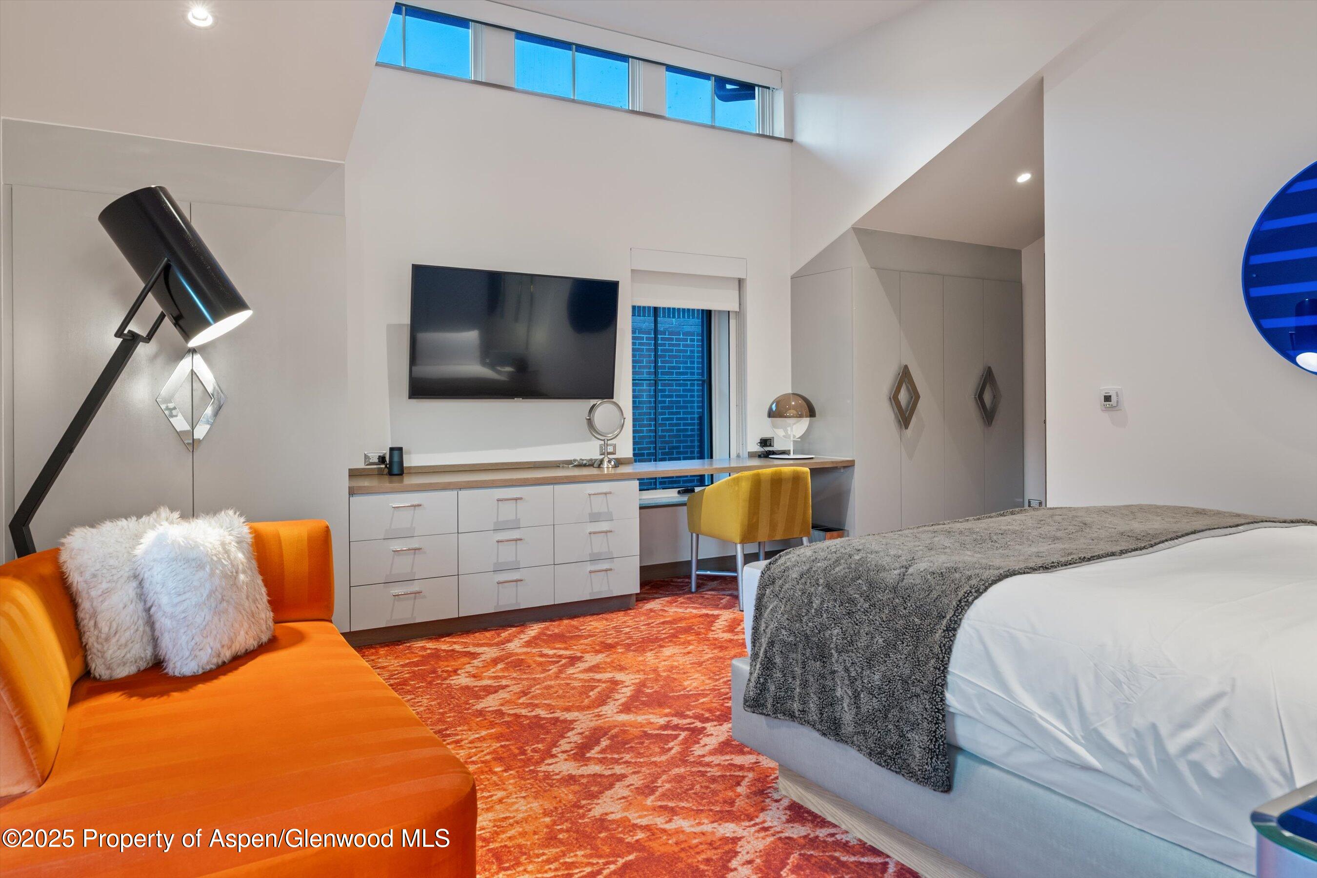 550 South Spring Street, Unit F10 110 Aspen, CO 81611 - Photo 26 of 58 a bedroom with a bed and flat screen tv