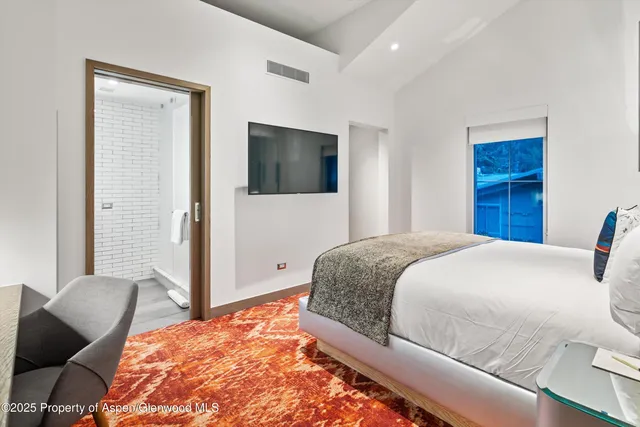 a bedroom with a bed dresser and a chair