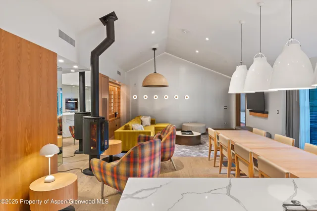 a dining room with stainless steel appliances kitchen island granite countertop a table chairs and a view of living room