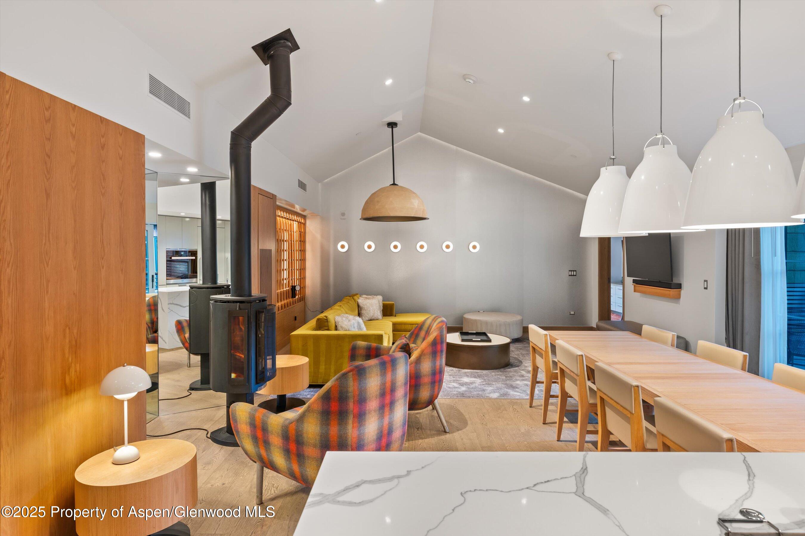 550 South Spring Street, Unit F10 110 Aspen, CO 81611 - Photo 5 of 58 a dining room with stainless steel appliances kitchen island granite countertop a table chairs and a view of living room