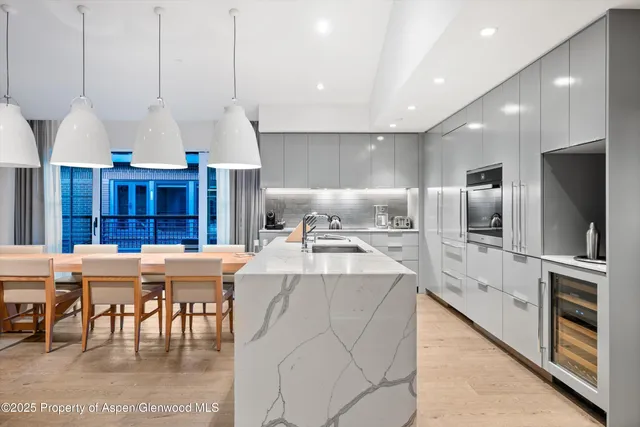 a kitchen with a sink appliances and a chandelier