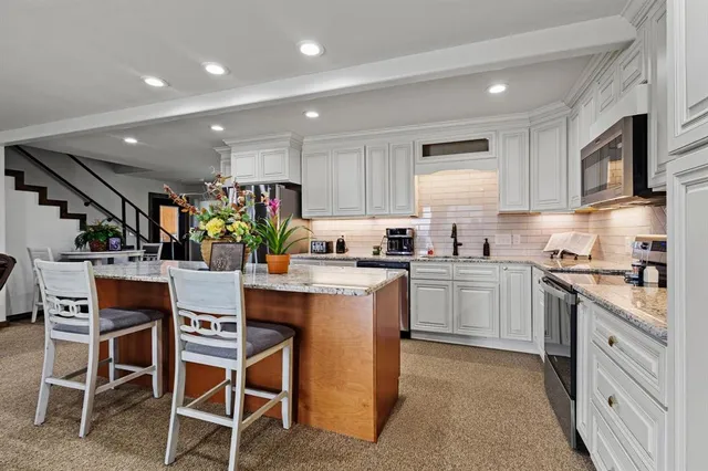 a kitchen with stainless steel appliances granite countertop sink stove and refrigerator