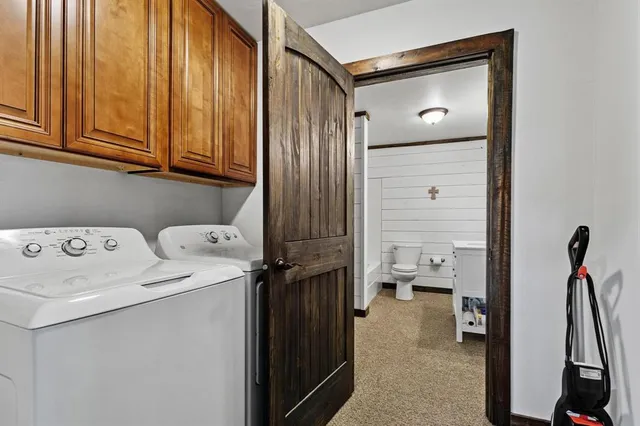 a kitchen with stainless steel appliances granite countertop a refrigerator a sink dishwasher a oven and a dining table with wooden floor