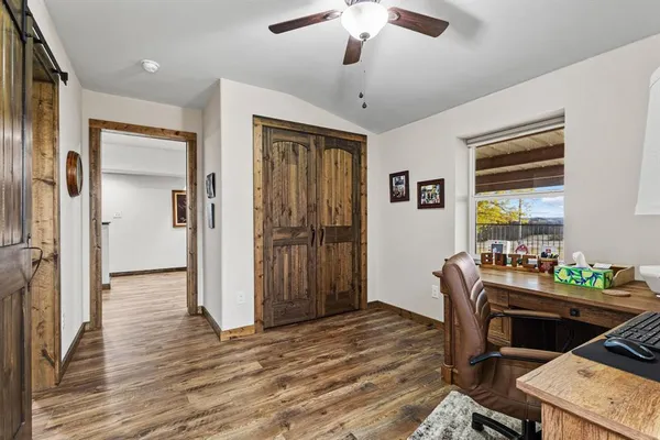 a view of a hallway with wooden floor and closet