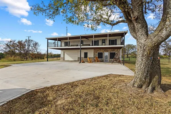 front view of a house with a large tree