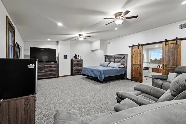 a spacious bedroom with a bed and a chandelier