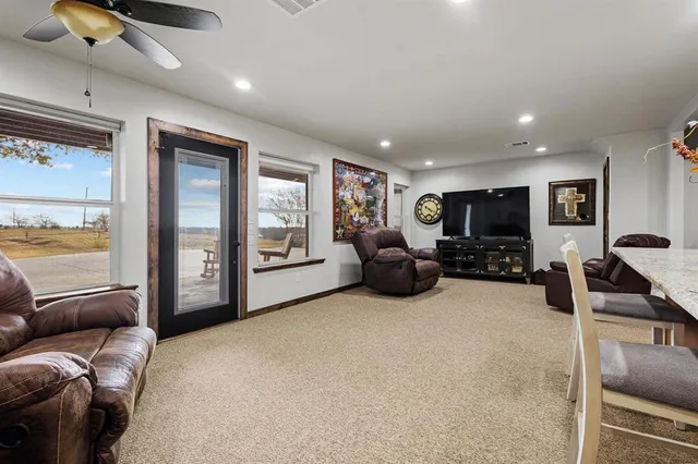 a living room with furniture a large window and flat screen tv