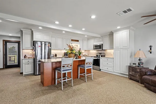 a kitchen with refrigerator and chairs