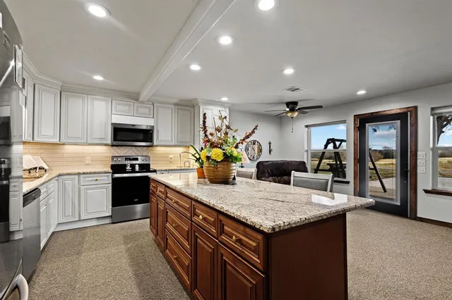 a kitchen with granite countertop a sink appliances and cabinets