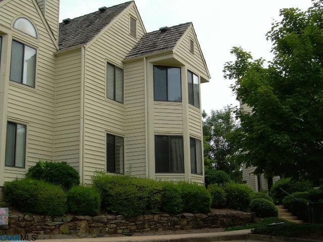 a view of a house with a yard and potted plants