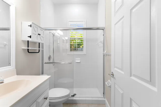 a bathroom with a sink a toilet and shower