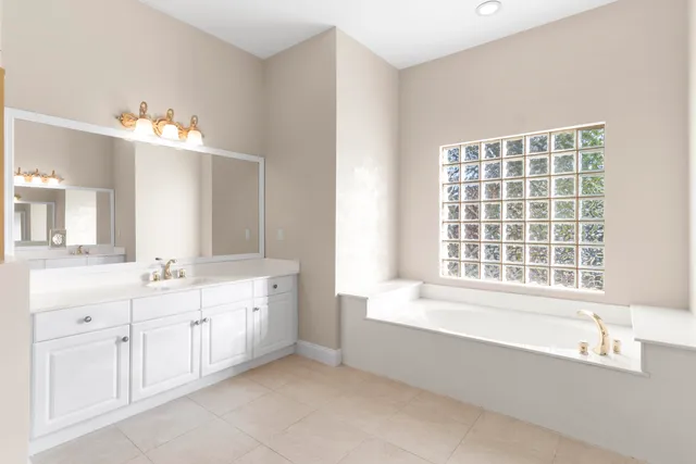 a bathroom with a tub sink and mirror