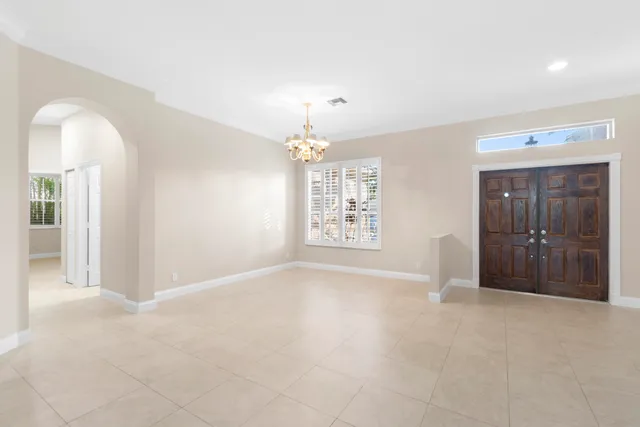 en empty room with windows and chandelier