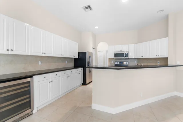 a kitchen with granite countertop white cabinets and stainless steel appliances