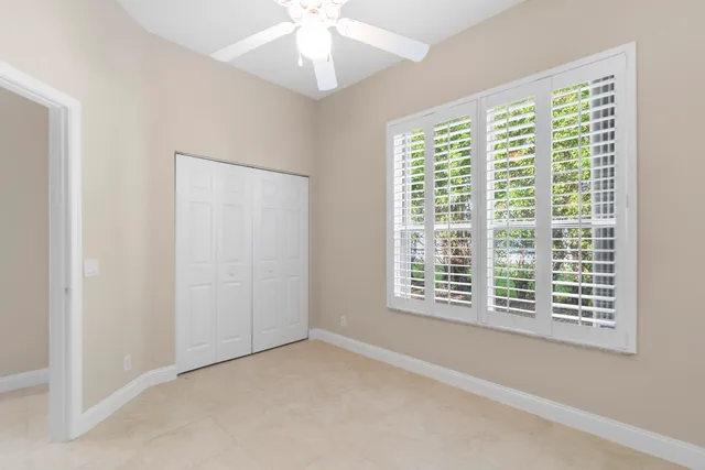 a view of an empty room with a window and a ceiling fan